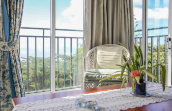 Gemütlicher Sessel vor einem Fenster mit Ausblick auf das Meer